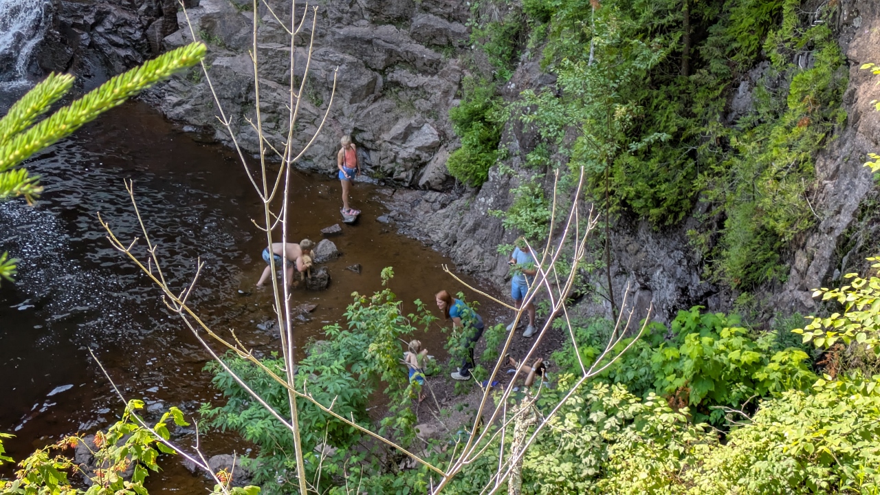 While Family Plays in Pool Below Falls