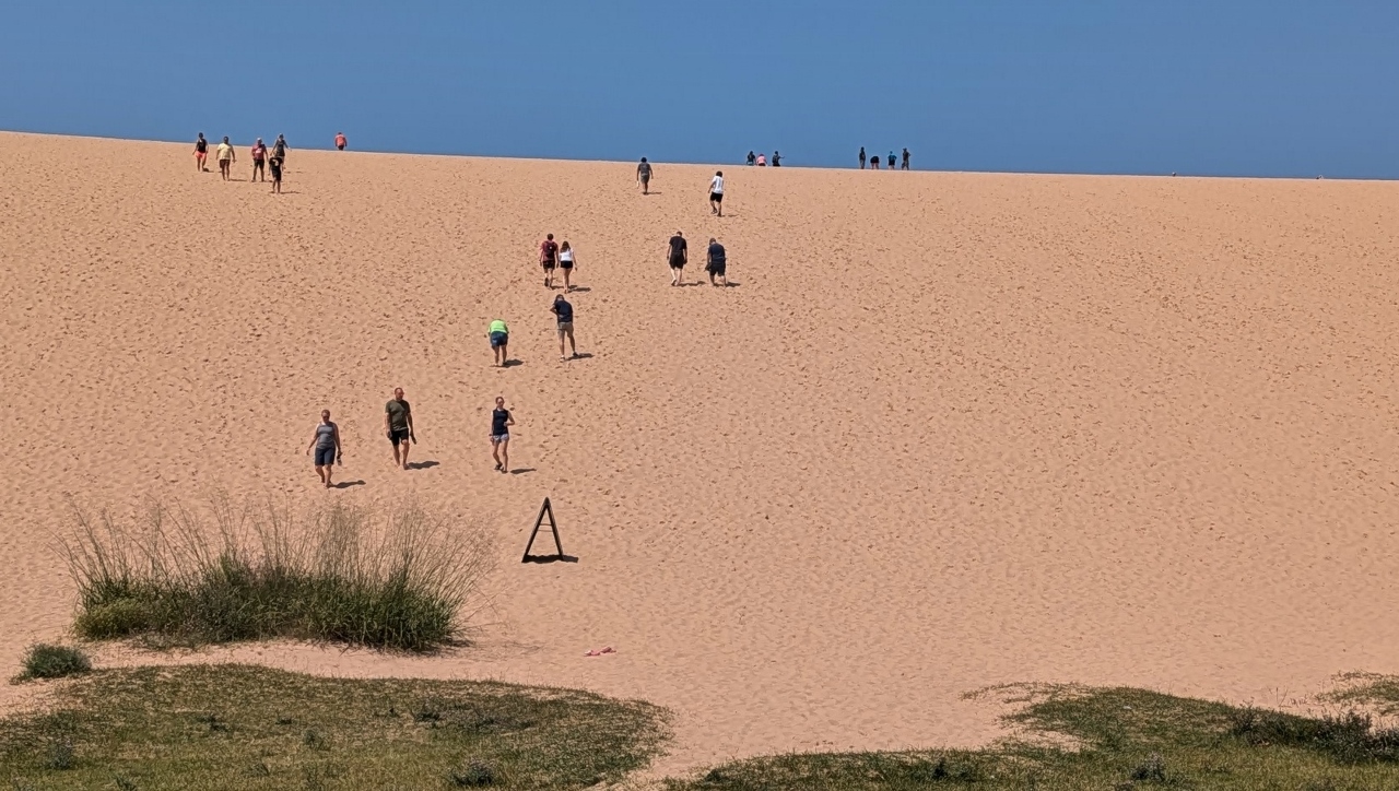 People Climbing Slope at Dune Climb