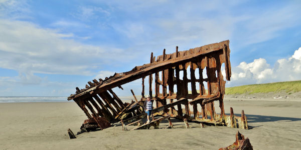 Sandy Poses inside Remains of Wreck of Peter Iredale on Beach at Fort Stevens SP