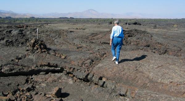 Following Trail Across Desolate Lava Landscape